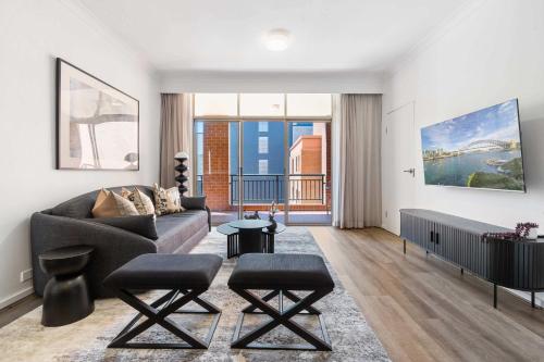 a living room with a couch and two stools at Camperdown Cozy Corner 5 in Sydney
