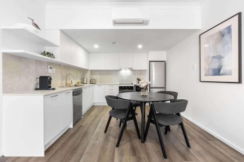 a kitchen with a table and chairs in a room at Camperdown Cozy Corner 5 in Sydney