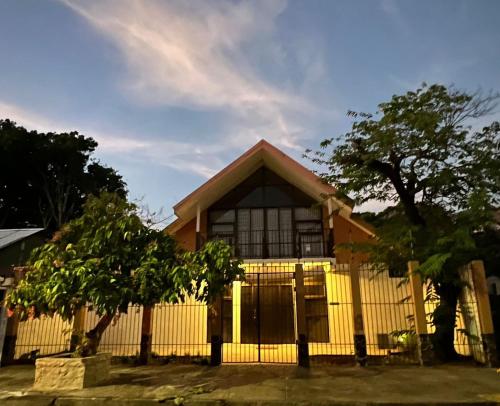 a yellow house with a fence in front of it at Villa de Playa - 4 Habitaciones in Puntarenas