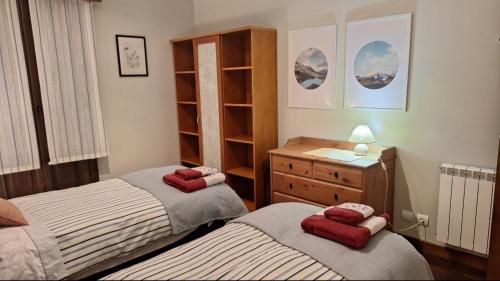 a bedroom with two twin beds and a dresser at Estancia con jardín entre golf y monte - cerca Logroño in Sojuela