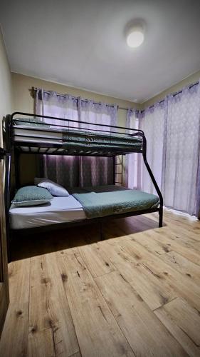 a bunk bed in a room with a wooden floor at Cabaña Rio Blamco in Guápiles