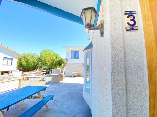 a patio with a blue bench next to a building at Bella casa en Los Molles Nº3 a 8 min de la playa in Los Molles