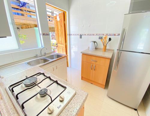 a kitchen with a stove and a refrigerator at Bella casa en Los Molles Nº3 a 8 min de la playa in Los Molles