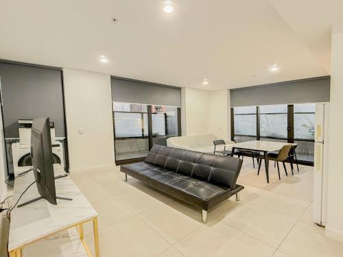 a living room with a couch and a table at Burwood Studios at St Luke Square in Sydney