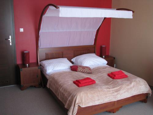 a bedroom with a bed with two red pillows on it at Willa Akacja in Gdynia