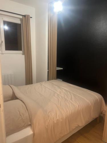 Ce lit se trouve dans un dortoir doté d'un mur noir. dans l'établissement Flixhouse, à Rouen