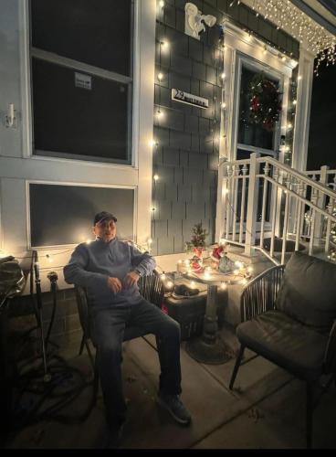 a man sitting in a chair on a porch at night at Dayton Dream in Newark