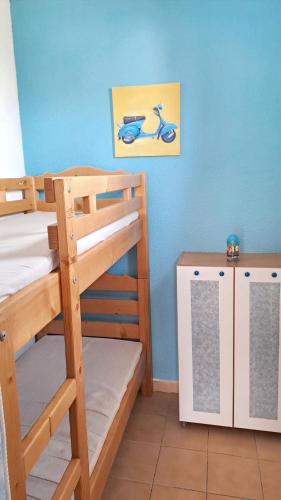une chambre avec deux lits superposés et un scooter dans l'établissement Appartement cosy Canet-en-Roussillon 25 m² vue sur le lac, à Canet