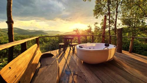 a bath tub sitting on a wooden deck with a view at Ecopousada Toca do Guará in Alto Paraíso de Goiás