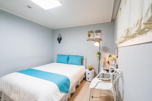 a small bedroom with a bed and a chair at Haeundae Beach Bexco in Busan