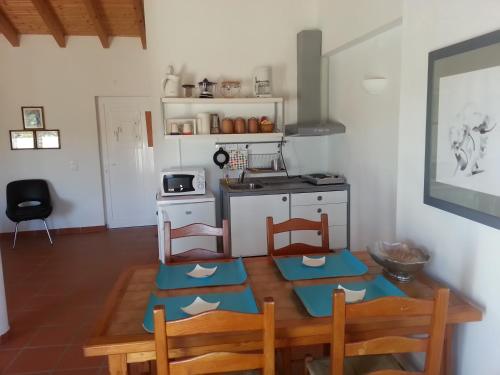 a kitchen with a table and two chairs and a kitchen with a stove at Casa da Osga in Tavira