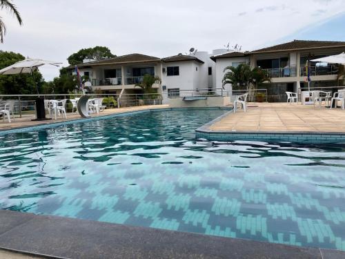 a swimming pool with blue water in front of a house at Casa Temporada Praia do Mutá in Porto Seguro