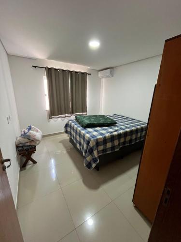 a small bedroom with a bed and a window at Casa Temporada Praia do Mutá in Porto Seguro