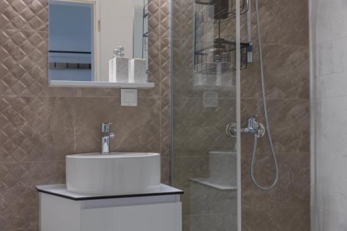 a bathroom with a sink and a glass shower at Liri's Home in Skopje