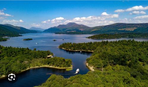 an aerial view of a lake with trees and a boat at Lomond View Lodge in Glasgow