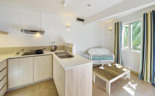 a kitchen with a sink and a table at Le Beachclub in Pereybere