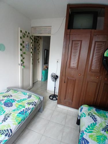 a bedroom with a bed and a wooden door at MANOA "Lugar de descanso" HABITACION CON VISTA A LA CIUDAD, FRESCO Y VENTILADO in Ibagué