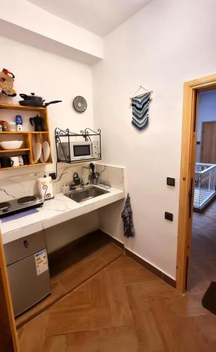 a kitchen with a sink and a microwave at Entire Studio Steps From The Kasbah Museum In The Ancient City in Tangier