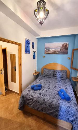 a bedroom with a bed with two blue pillows on it at Entire Studio Steps From The Kasbah Museum In The Ancient City in Tangier