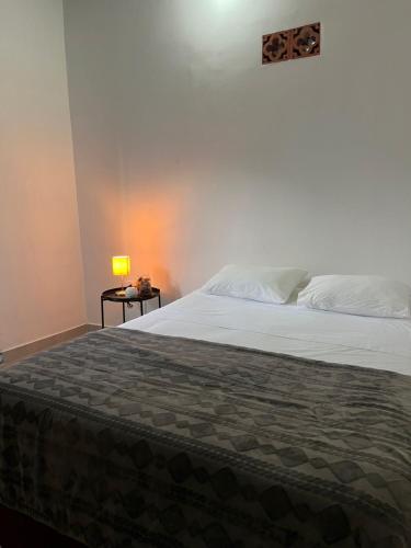 a bedroom with a bed and a table with a lamp at Casa Blue Jericó in Jericó