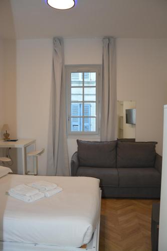 a living room with a bed and a couch at Maison Jacob - Hyper centre - Maison historique - Air conditioning - Wifi in Avignon