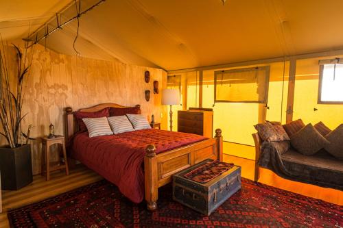Un dormitorio con una cama y un sofá en una habitación. en Glamping at the Tasman Cloud, en Lower Moutere