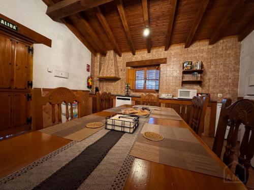 a kitchen with a large wooden table in a room at El Desván del Trigo in El Barraco