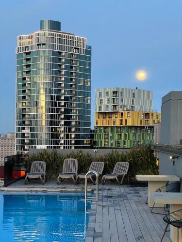 a pool on the roof of a building with tall buildings at St Kilda Fitzroy St apt in secure luxury building in Melbourne
