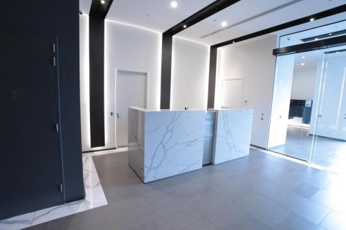 a large white room with a counter in the middle at St Kilda Fitzroy St apt in secure luxury building in Melbourne