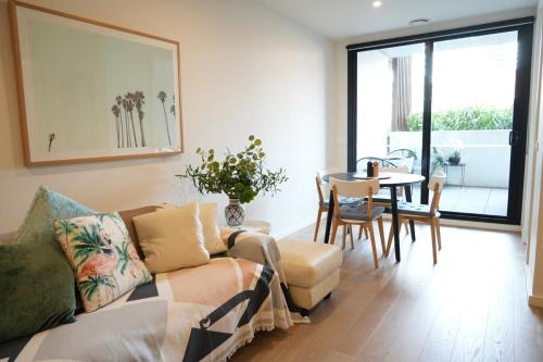 a living room with a couch and a table at St Kilda Fitzroy St apt in secure luxury building in Melbourne