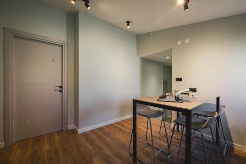 Una habitación con una mesa y sillas y una puerta. en Moon apartment 2, en Podgorica
