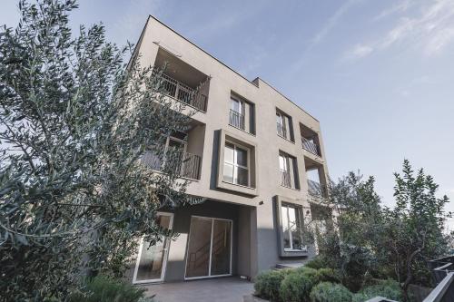 ポドゴリツァにあるMoon apartment 2の窓と木々のある白い建物