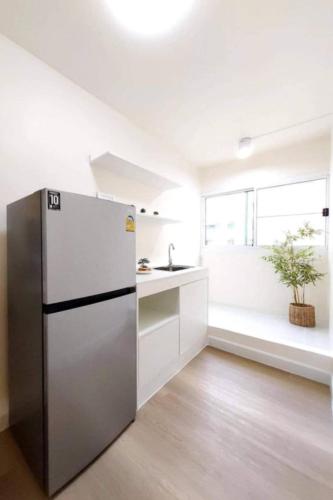a kitchen with a refrigerator and a sink at Impact poppula P1 by เจี๊ยบ in Thung Si Kan