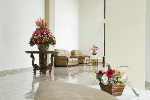 a lobby with two chairs and a table with flowers at Hotel Sepanak by Amazing in Curup