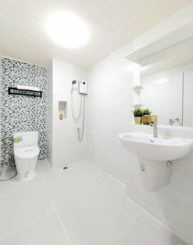 a white bathroom with a sink and a toilet at Impact poppula P1 by เจี๊ยบ in Thung Si Kan