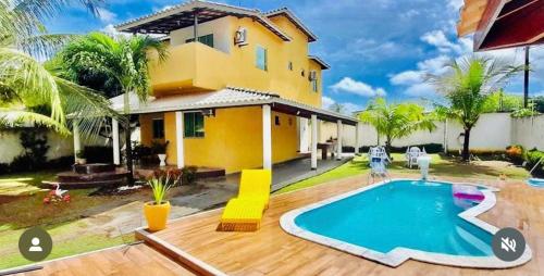 a house with a swimming pool in front of it at Residencial em Família in Arembepe