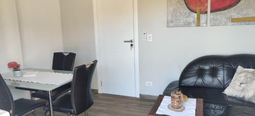 a living room with a table and a black leather chair at Casa Nathan! 2 Zimmer, Internet, Küche, Cosina, Parking, Lavanderia, Sauna! Barrio Esperanza! Central! in Hohenau