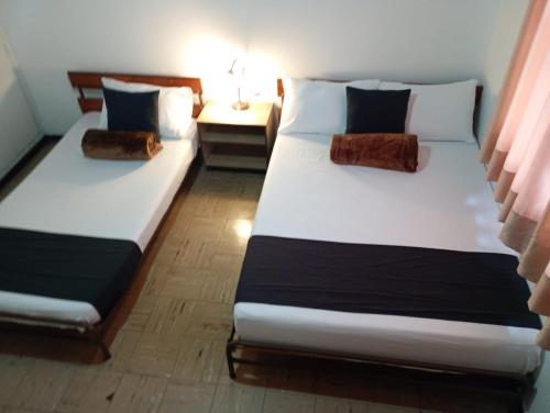 two twin beds in a room with at Hotel Alpino Armenia in Armenia