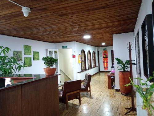a lobby with a bar with chairs and plants at Hotel Alpino Armenia in Armenia