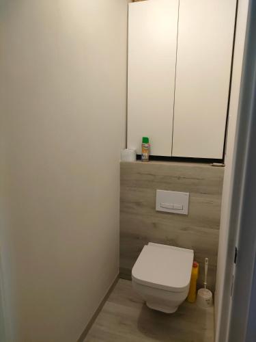 a bathroom with a white toilet and a mirror at Apartament 2 pokoje in Ostrowiec Świętokrzyski