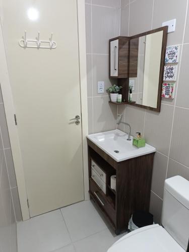 a bathroom with a sink and a mirror and a toilet at Apto Paris in Santa Maria