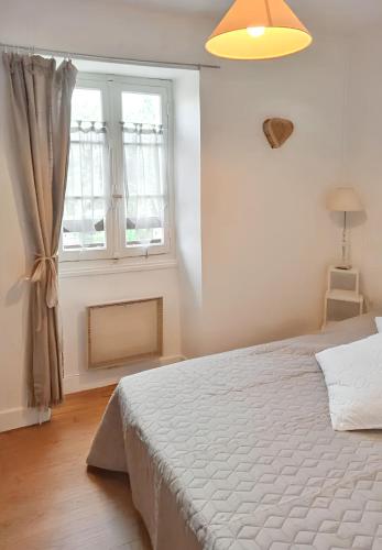 une chambre avec un lit blanc et une fenêtre dans l'établissement Maison charmante à Lavercantière avec piscine partagée, à Lavercantière