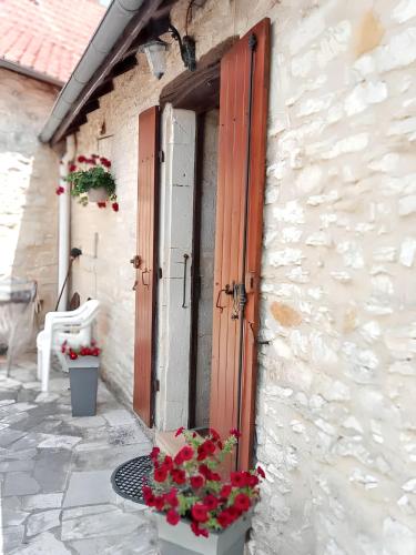 un bâtiment avec des fleurs devant une porte dans l'établissement Maison charmante à Lavercantière avec piscine partagée, à Lavercantière