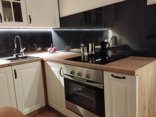 a kitchen with white cabinets and a stove top oven at Apartament 2 pokoje in Ostrowiec Świętokrzyski