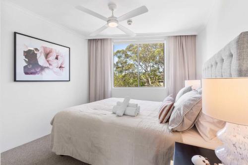 a white bedroom with a bed and a window at Camperdown Cozy Corner 6 in Sydney