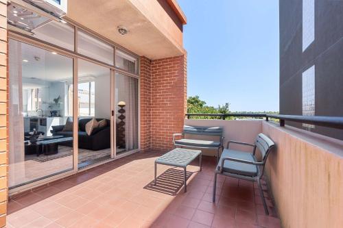 a balcony with two chairs and a table and a couch at Camperdown Cozy Corner 6 in Sydney
