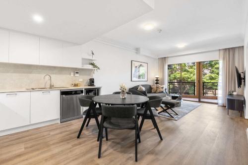 a kitchen and living room with a table and chairs at Camperdown Cozy Corner 7 in Sydney