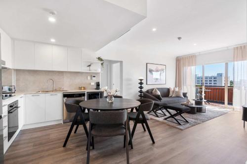 a kitchen and living room with a table and chairs at Camperdown Cozy Corner 10 in Sydney