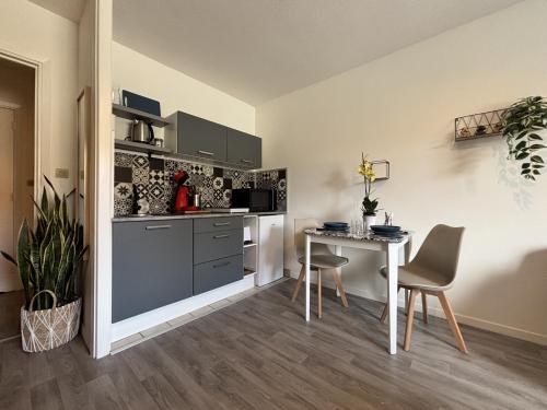 a kitchen with a table and a table and chairs at Ô repos - Studio - Parking - 1 lit - 2 pers in Châtel-Guyon