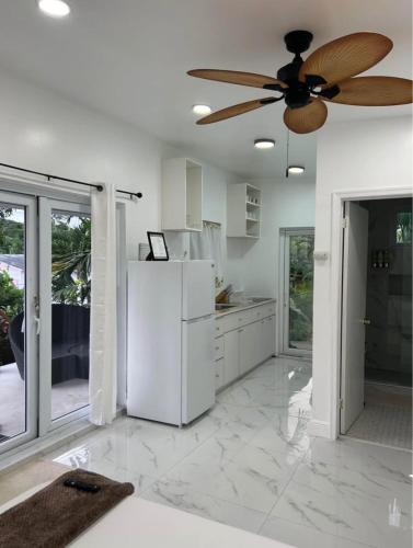 una cucina con un frigorifero bianco e un ventilatore a soffitto di The Garden Oasis a Nassau
